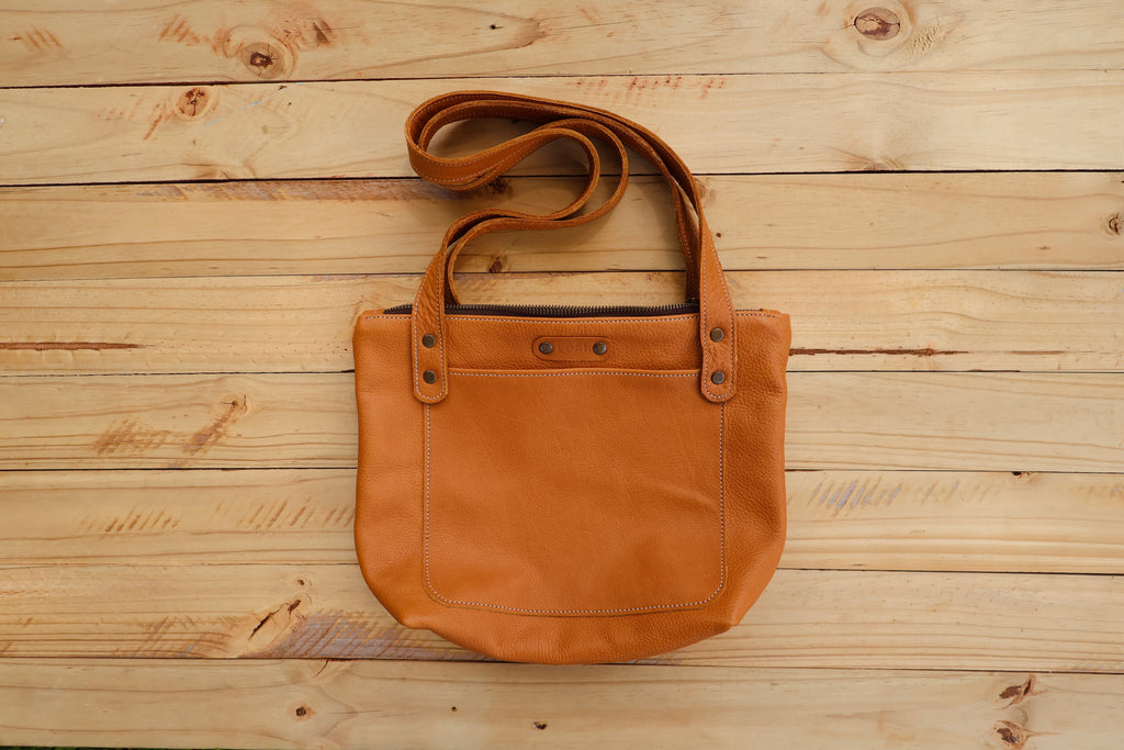 Baobab Tote– A classic leather tote featuring a functional top zip closure and a front pocket, beautifully lined with Shwe Shwe fabric