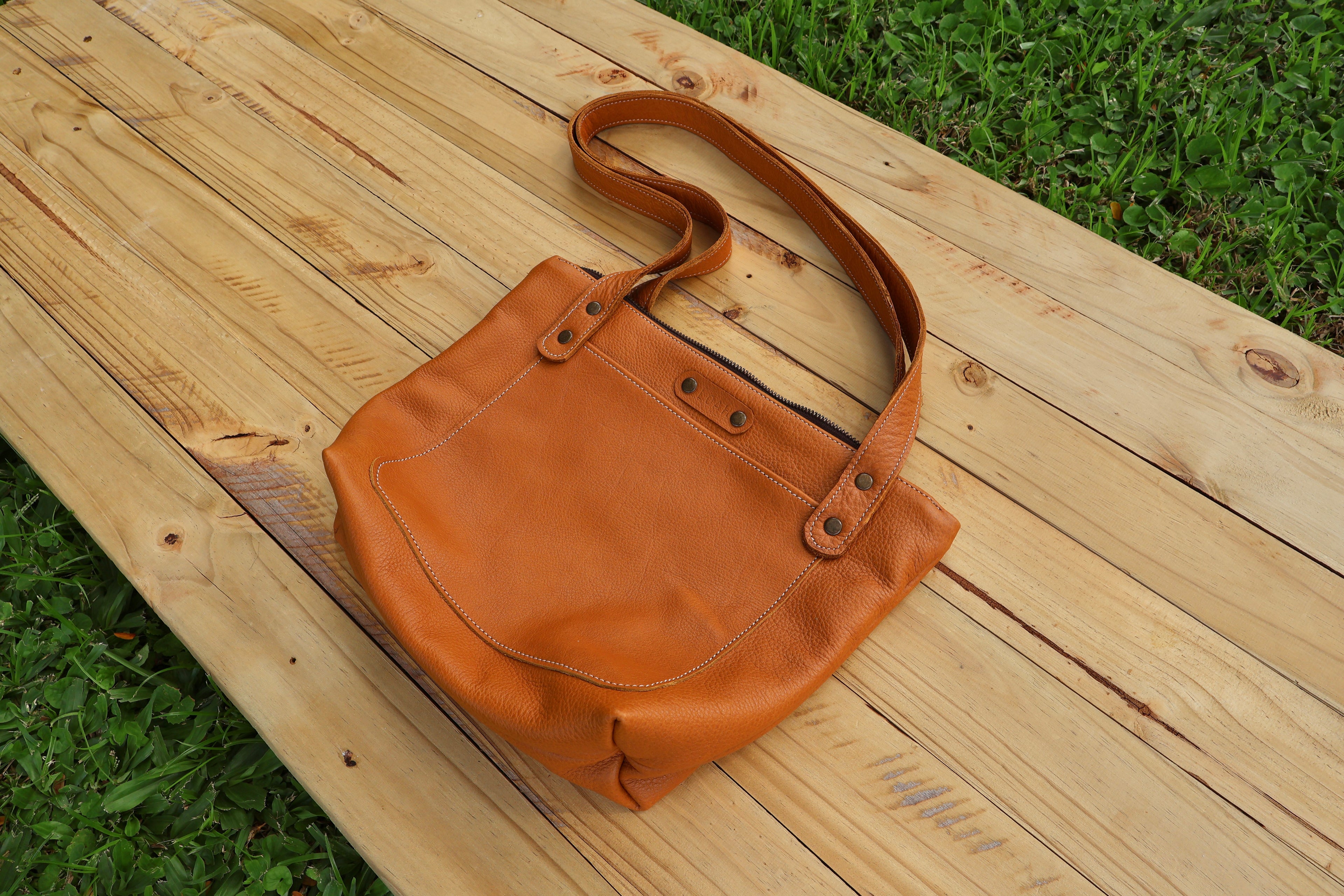 Baobab Tote– A classic leather tote featuring a functional top zip closure and a front pocket, beautifully lined with Shwe Shwe fabric