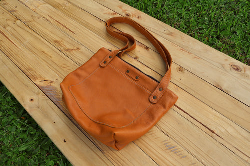 Baobab Tote– A classic leather tote featuring a functional top zip closure and a front pocket, beautifully lined with Shwe Shwe fabric